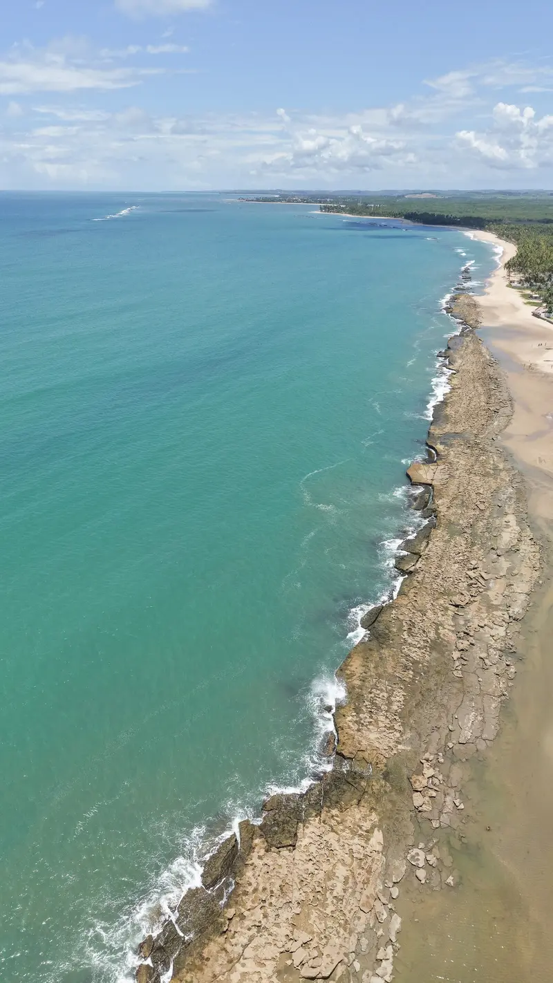 Faixa de arrecife e mar verde-água ao longo da costa