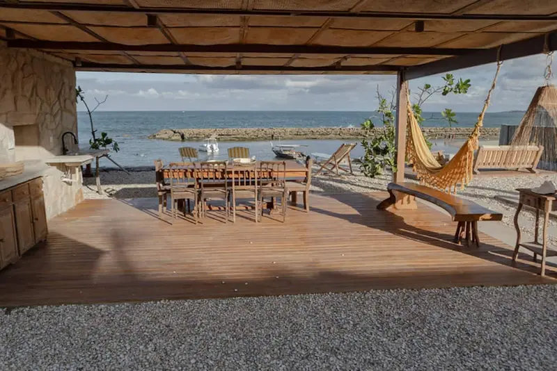 Gazebo aberto para o mar, com rede e mesa comprida