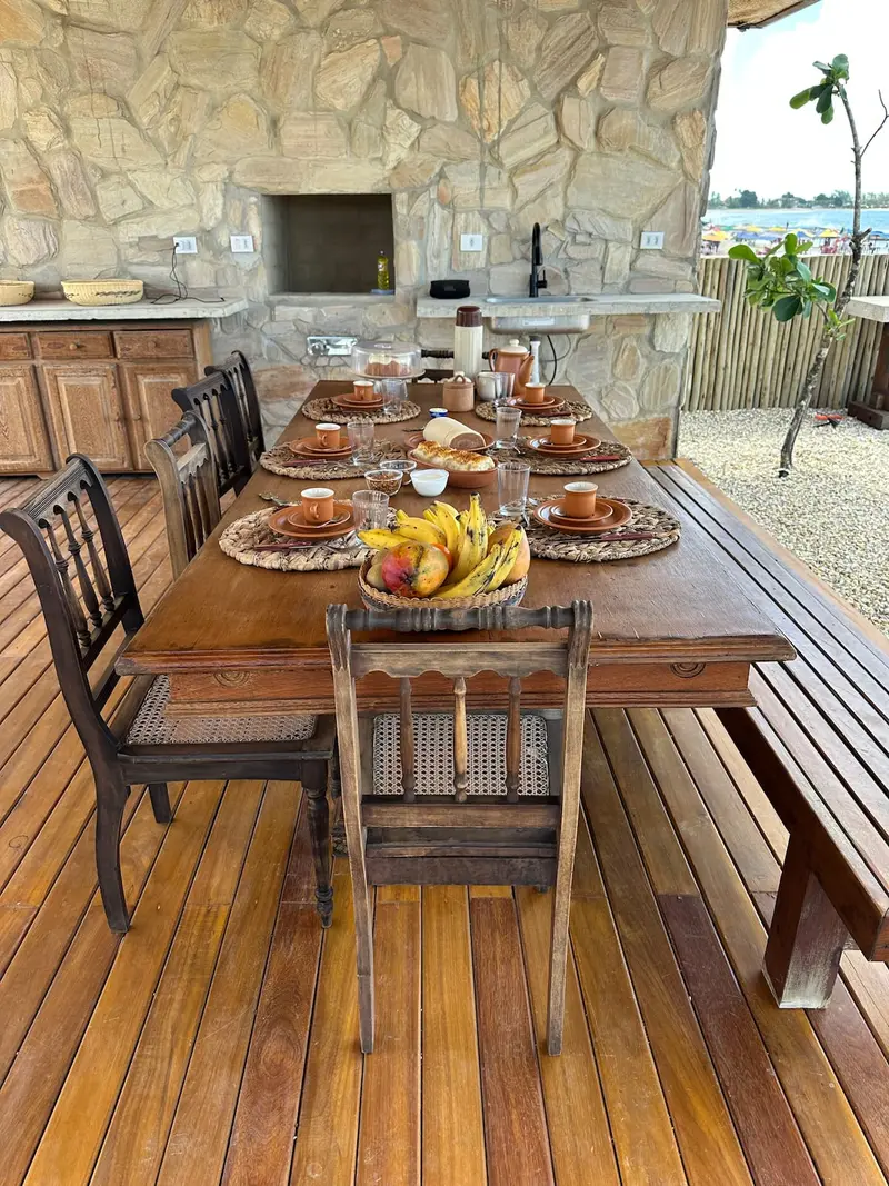 Mesa posta ao lado da churrasqueira de pedra do gazebo