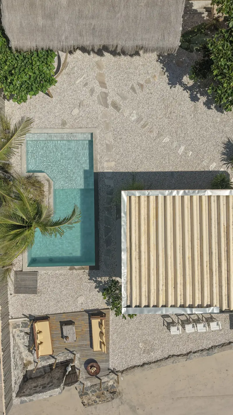 Vista de cima da piscina, do deck e do toldo listrado