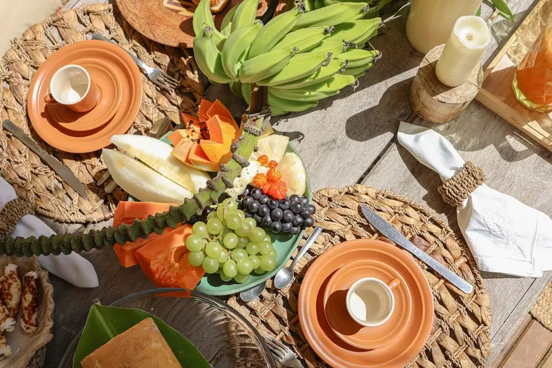 Mesa vista de cima com cerâmica, bananas e frutas
