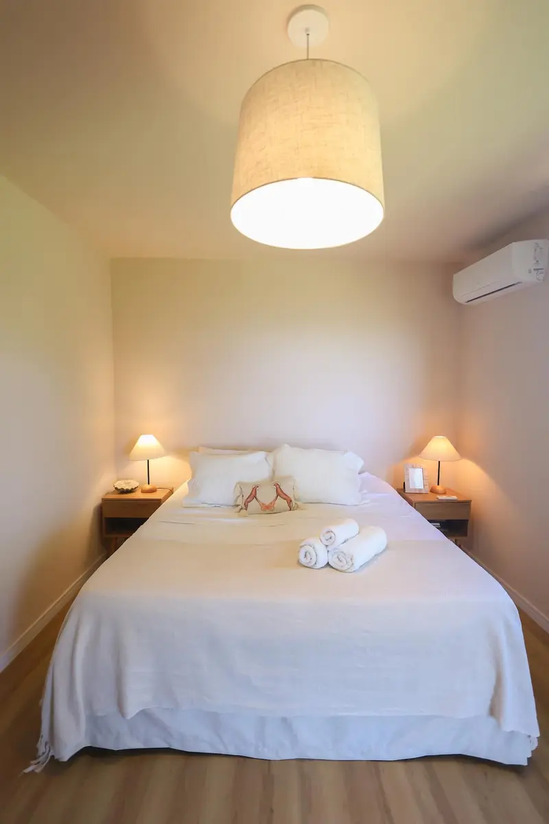 Quarto 3 com cama de casal e abajures acesos