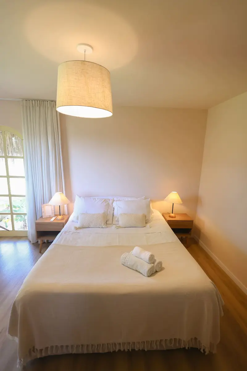 Cama do Quarto 2 com janela em arco ao lado